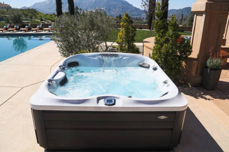 Spa Jacuzzi J-475 em área externa ao lado da piscina