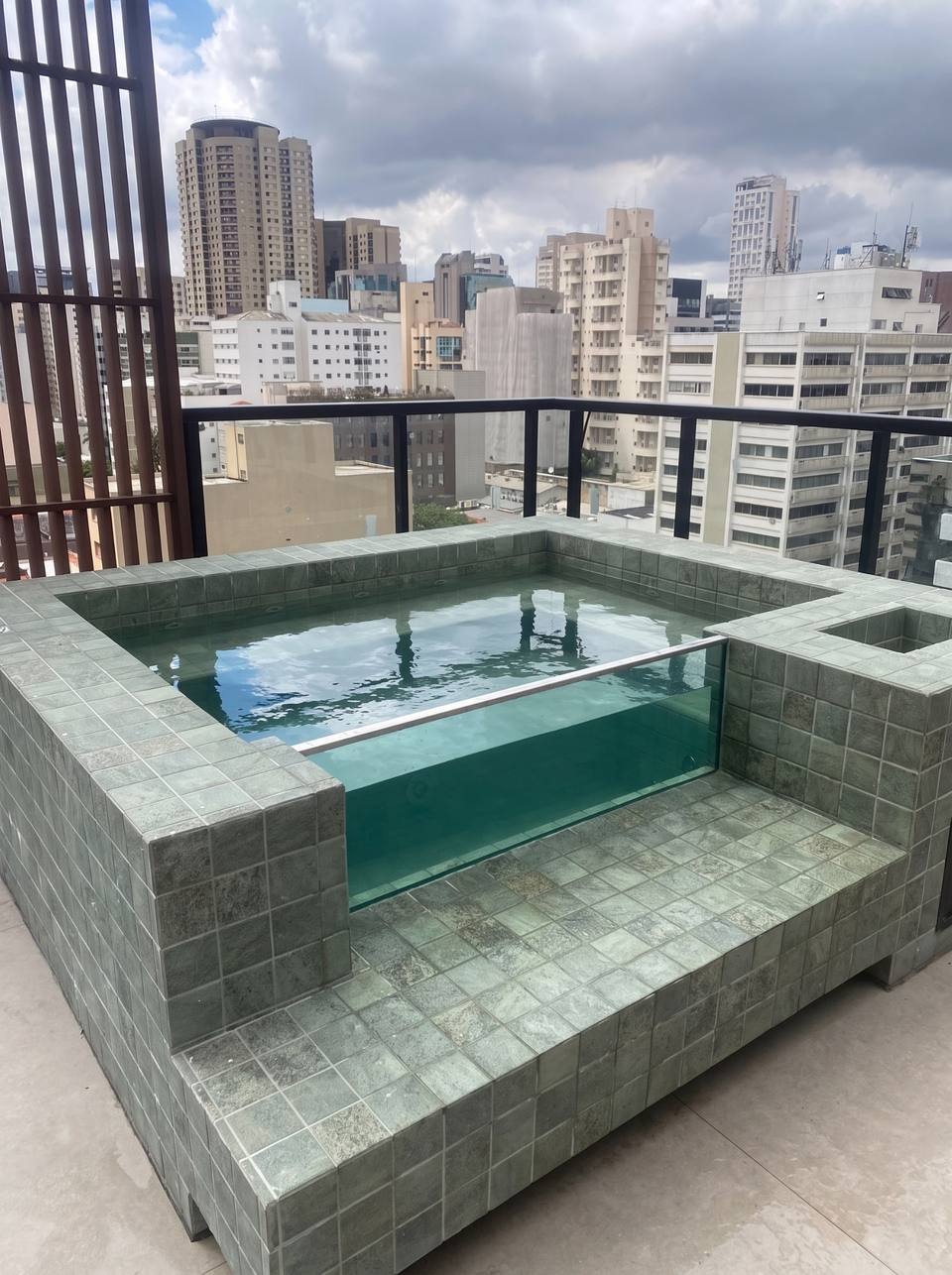 Spa de Cerâmica da Relaxy com frente de vidro e revestimento verde no terraço de um prédio no Itaim Bibi