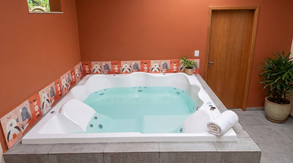 Spa Cassino Mondialle embutido em base de alvenaria com porcelanato cinza e faixa de azulejos decorados, em Caieiras